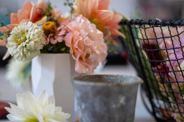 Kırsal vazo ve kablo sepetli beyaz bir vazoda çiçeklerin yakın çekimi