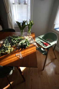 Laleler ve Karanfiller Mutfak Masasında Yüksek Sandalyeli