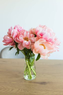 Taze kesilmiş şakayık renkli pastel buketi ahşap masada.