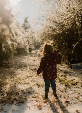 Toddler playing in snow outside clipart