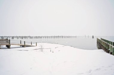 Huzurlu bir kış sahnesinde, karla kaplı rıhtım ve donmuş rıhtım