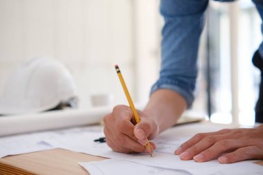 Genç mimar ev planları çiziyor.