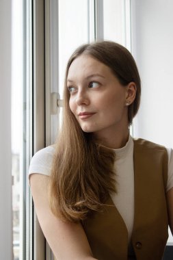 20-25 yaşlarında, uzun saçlı bir kızın portresi.