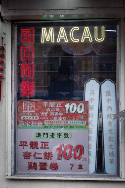 Asyalı bir adam, geleneksel bir Çin dükkanının penceresinin arkasında.