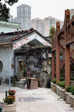 Arka planda yüksek binalar olan terk edilmiş eski bir mülk.