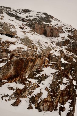 Kış boyunca karla kaplı kahverengi kaya