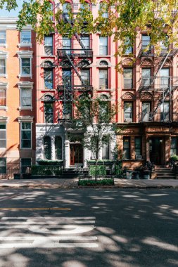 East Village 'da ağaçlarla kaplı cadde boyunca tarihi kahverengi taşlar, anne.