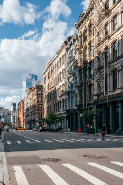 Yayalar ve bisikletçiler Manhattan 'da canlı bir caddede yol alırlar.