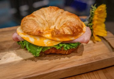 Jambonlu, peynirli ve marullu taze kruvasanlı sandviç.