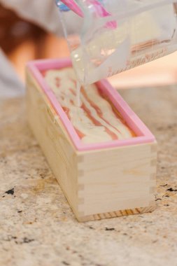 Kalıpta altın mika kıvrımlı sabun tabakasının üzerine dökülüyor.