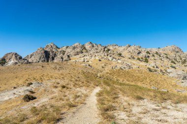 Toprak bir yolu olan kayalık bir yamaç.