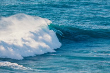 Bir sörfçü Portekiz, Nazare 'de büyük bir dalgada sörf yapıyor.