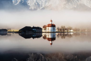 Morning fog over church St. Bartholomew on Konigsee lake clipart