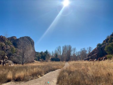 Kuru otlaklarda kayalık uçurumlarla sarmalanan toprak izleri.