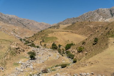 Aralarından bir ırmak akan bir dağ sırası.