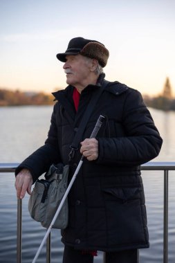 Çubuklu Yaşlı Adam Bir Köprüden Kıyıya Bakıyor