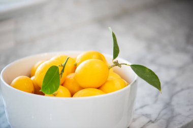 Mermer mutfak tezgahında bir kase taze limon.