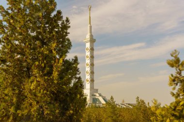 Tepesinde altın haç olan uzun beyaz bir bina.