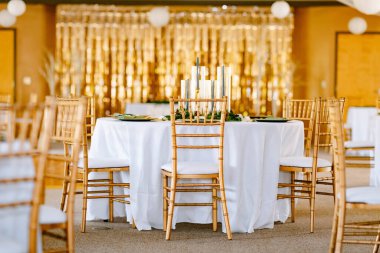 Altın koltuklar ve mum ışığında mükemmel bir düğün resepsiyonu.