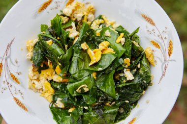 Kızarmış Melinjo tabakta yumurta ile gider.