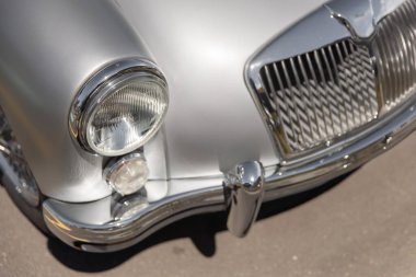 Mat gümüş renkli bir İngiliz arabasının ön ızgarası ve farları.