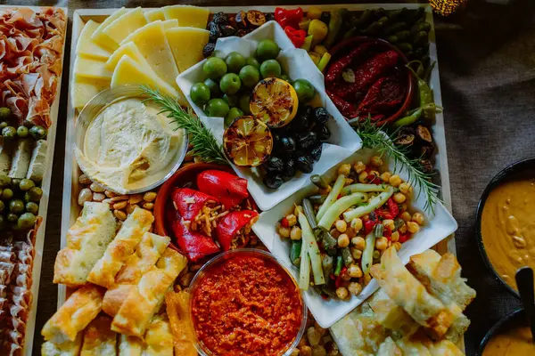 Peynirli, zeytinli ve soslu canlı bir şarküteri tahtası.