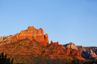 Altın gün batımı ışığında kırmızı kaya oluşumları