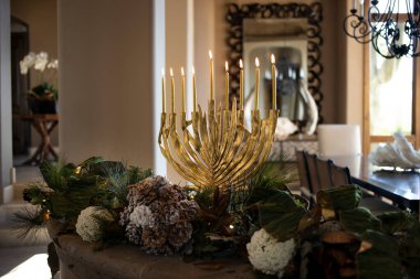 Ev ortamında mum yakan altın menorah.