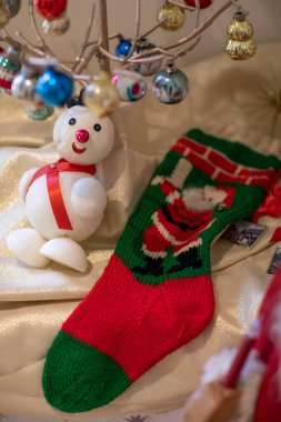 Minyatür bir kardan adam figürü Noel çorabının yanında sergileniyor