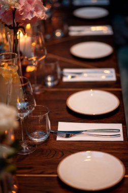 Tabaklar ve çatal bıçaklar ahşap masada.