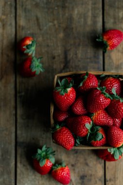 Taze, olgun çilekler Kırsal ahşap bir sepetin içinde masada.