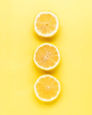 Sarı arka planda üç dilim limon manzarası.