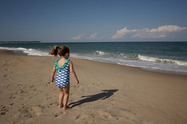 Cape Hatteras Ulusal Sahilinde oynayan bir çocuğun arkasında