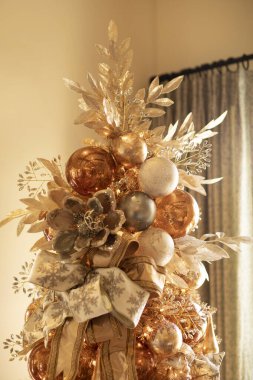 Altın Noel ağacının tepesinde çeşitli süslerle