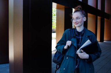 Modern üniversite binasının yanındaki genger kızı.