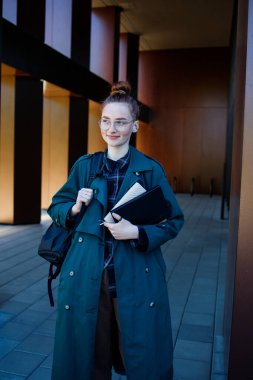 Modern üniversite binasının yanındaki öğrenci ya da işçi kız.