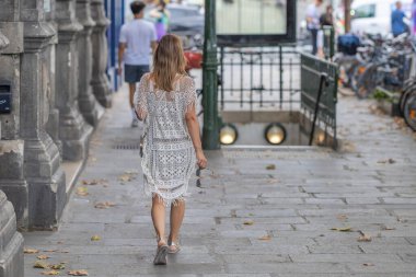 Paris metro istasyonuna doğru yürüyen bir kadın.