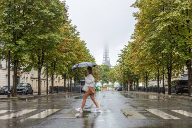 Paris 'te Eyfel Kulesi yakınlarında bir yerden geçen bir kadın.