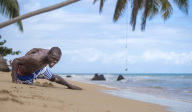 Sahilde tek elle şınav çeken adam.