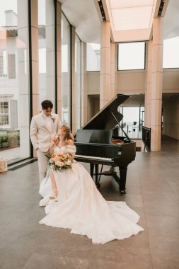 Gelin ve damat düğün yerinde romantik bir piyanoyla paylaşıyorlar.