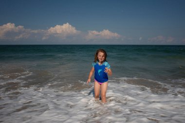 Gülümseyen genç kız dalgalarda oynuyor Outer Banks 'de
