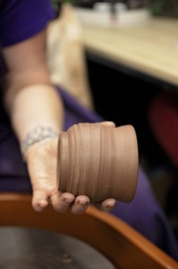 Potter, yumuşak bir dokusu olan yeni yapılmış bir kil parçasını tutuyor.
