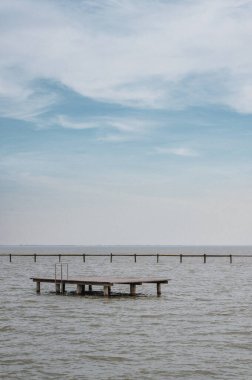 İnsan yapımı bir adayla gölün üzerinde Horizont.