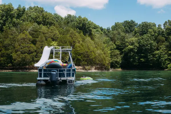 Yaz günü gölde duba teknenin yanında yüzen bir kadın.