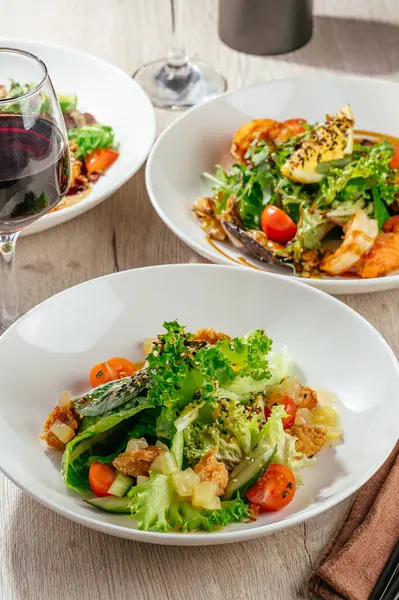 Sebzeli salata, susam, karides ve bir bardak şarap.