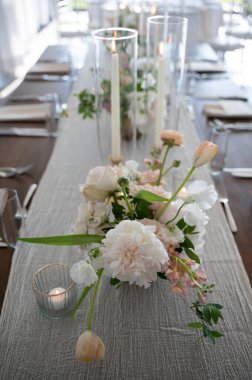 Zarif bir sekmenin üzerinde mumlar olan romantik bir çiçek süsü.