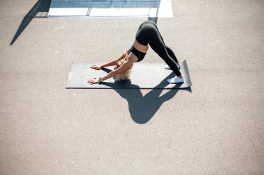 Yoga pozunda minderin üzerinde duran esnek kadın.