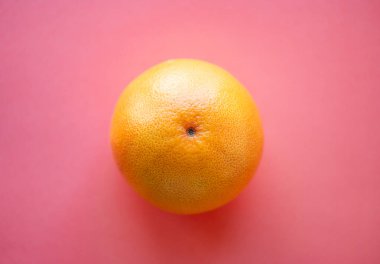 Pembe arka planda tek bir greyfurdun genel görünümü.