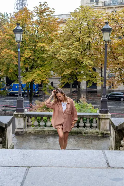 Paris 'teki Eyfel Kulesi' nin yanındaki merdivenlerden çıkan kadın.