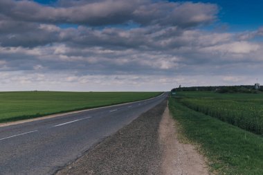 Bulutlu Gökyüzünün Altındaki Yeşil Tarlalarda Boş Ülke Yolu